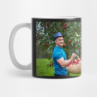 Farmer picking apples in a basket Mug